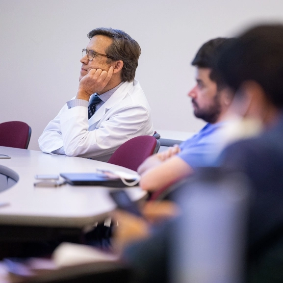 Faculty members listening to a lecture.