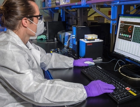 A Ph.D. student works at the computer in a lab. 