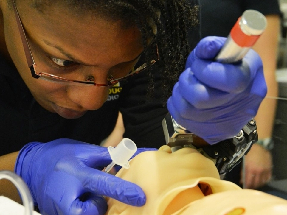 A medical student practices airway techniques in the simulation center.