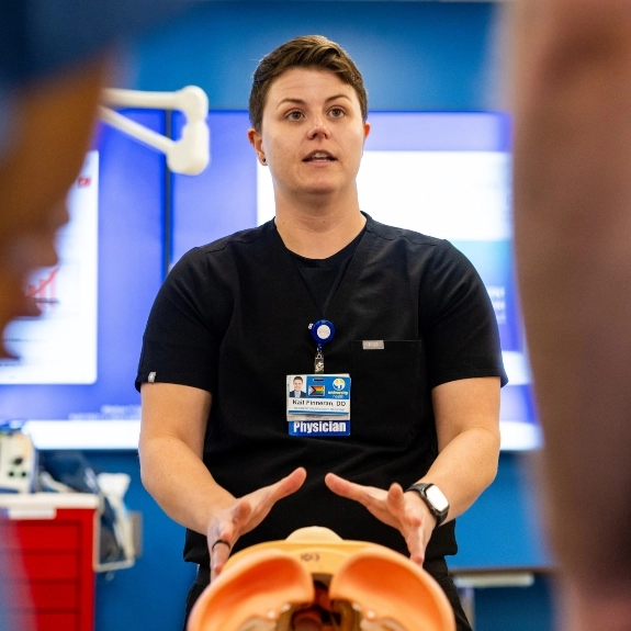 A teaching physician demonstrating airway procedures to students in a simulation classroom.