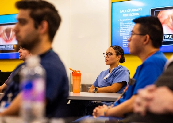 Medical students looking towards the front of a room during a lecture.