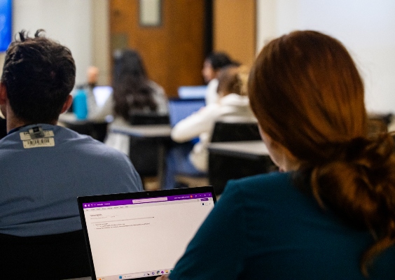 A medical student working on her laptop during a class.