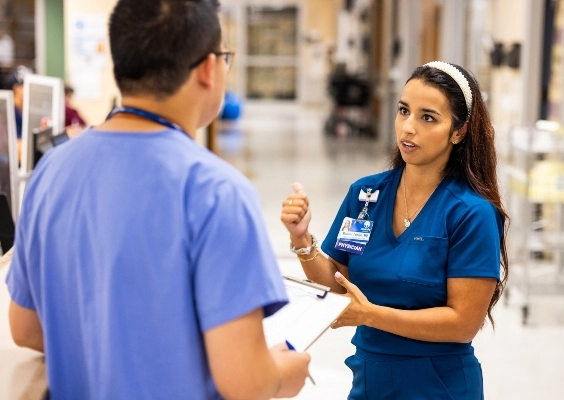 Faculty members talking in a hospital hallway.