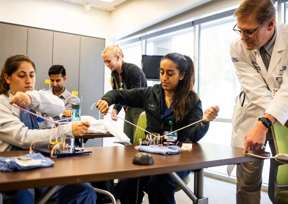 Students practicing sutures in a classroom. 