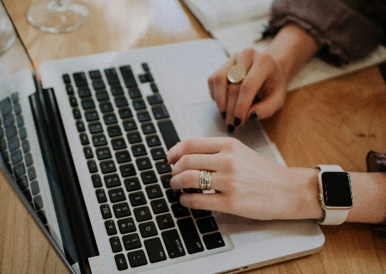 A closeup of a students hands as they type on a laptop.