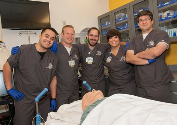 Several MSA students posing for a photo and smiling in the simulation lab.