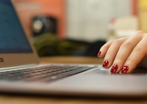 Closeup of a person's hands as they type on a laptop.