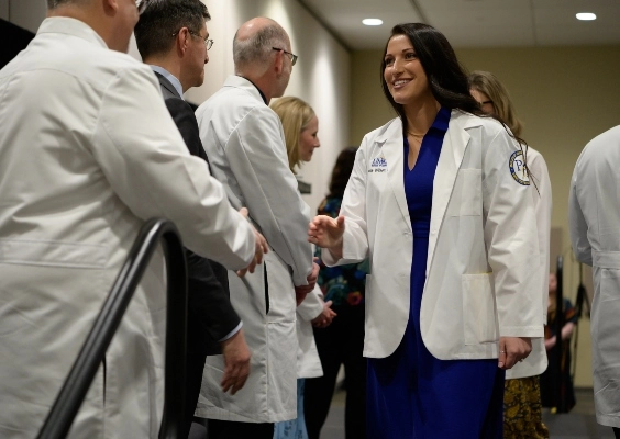 A PA student shakes faculty members' hands during the PA White Coat ceremony.