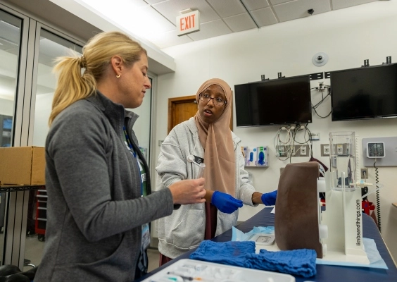 Two people work in skills lab. 