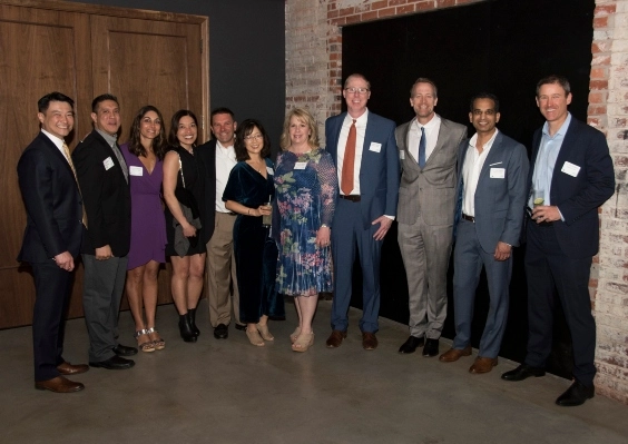 A group of School of Medicine alumni stand together and pose for a photo.