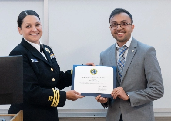 A person receiving the Take Wing award from the event's presenter.