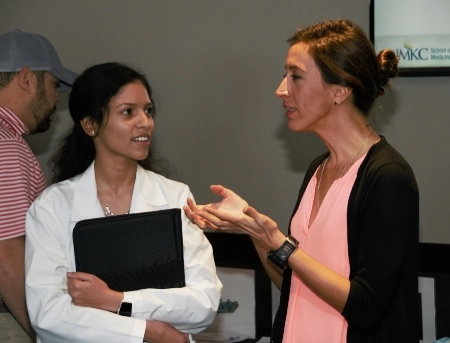 Two people talking at a School of Medicine event.