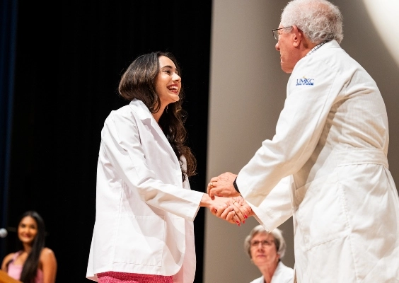 An M.D. student receives her white coat during the White Coat Ceremony.