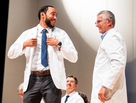 A medical student receives his white coat during the White Coat ceremony.