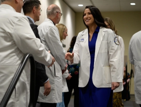 A medical student shakes a faculty member's hand during the School of Medicine's White Coat Ceremony.