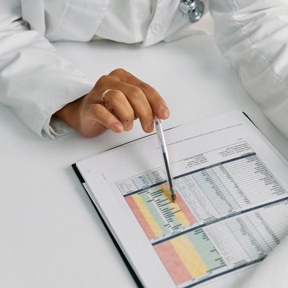 A physician looking at medical data on a page.