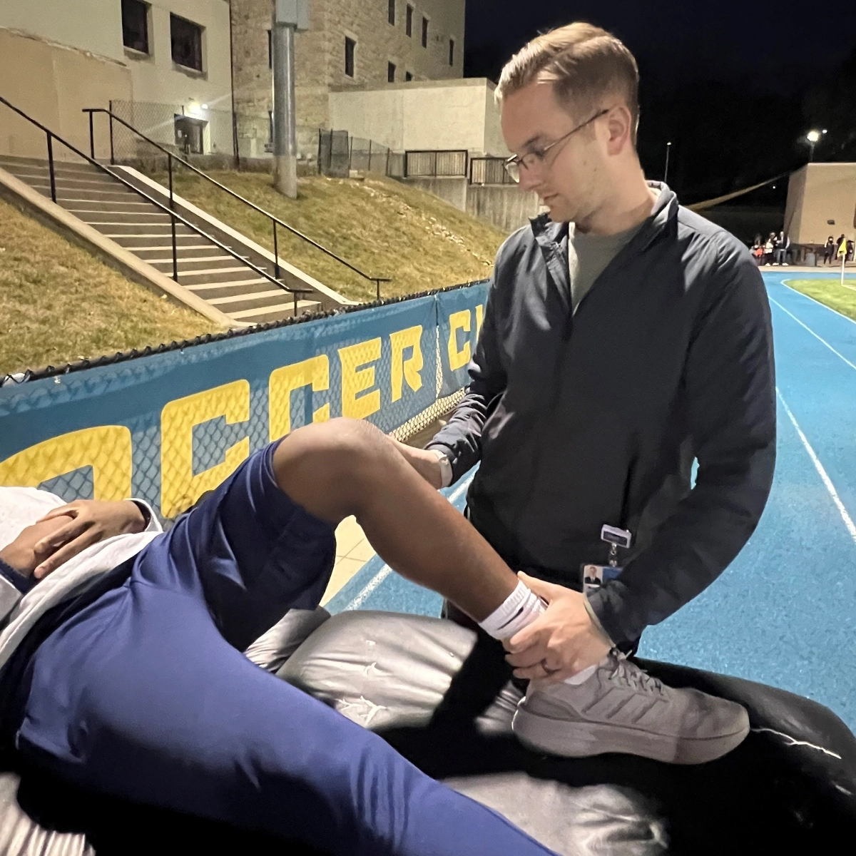 A sports medicine fellow helping an athlete.