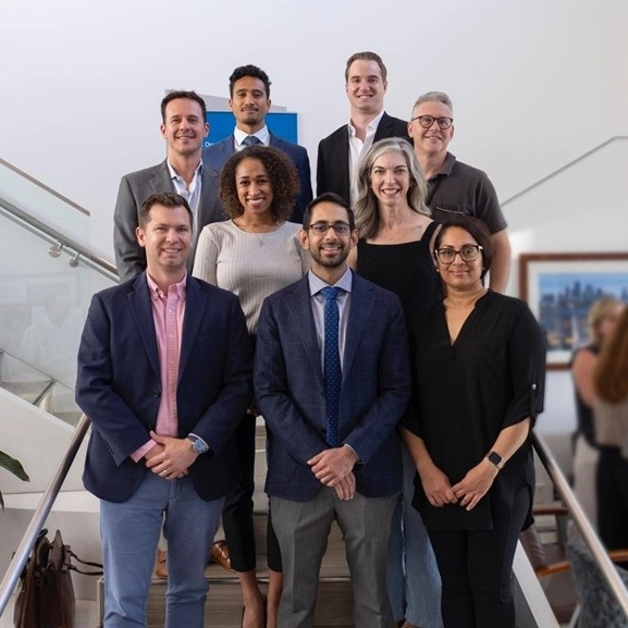 Department of Dermatology faculty standing on stairs and smiling for a group photo.