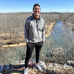 Ryan outside with a river and valley in the background