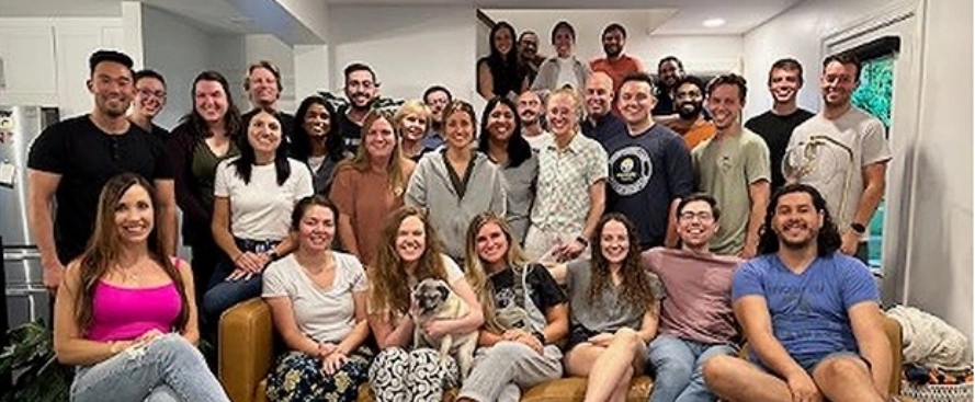 Emergency medicine residents and faculty take a group photo in someone's house.