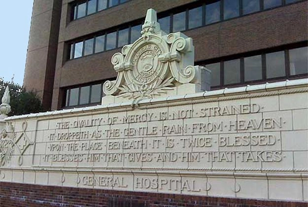 The sign for Kansas City's old general hospital, which features a quote from Shakespeare carved in stone. 