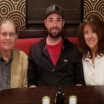 Portrait of Jace Shell with his parents at a restaurant.