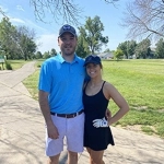 Portrait of Jaime Wilson with her partner at a golf course.