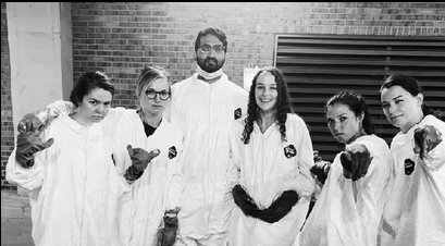 Emergency medicine residents dressed in lab gear making funny faces.