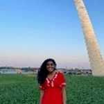 Portrait of Sneha Sibimon in front of the St. Louis Arch.