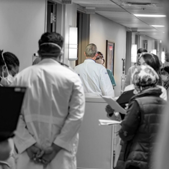 Internal medicine faculty and residents talking in a hospital hallway.