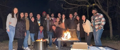 IM residents pose for a photo around a campfire.