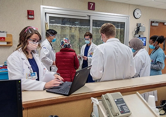 A resident checks patient information at a hospital work station.