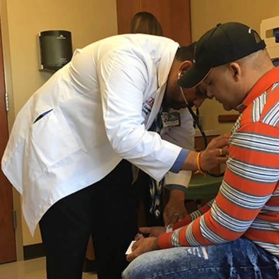 A fellow providing patient care at a hospital clinic.