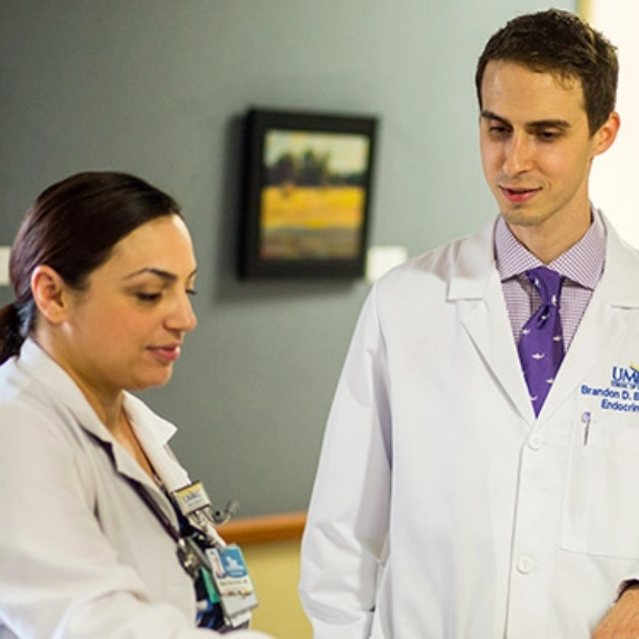 A fellow talking with a faculty member about patient care.