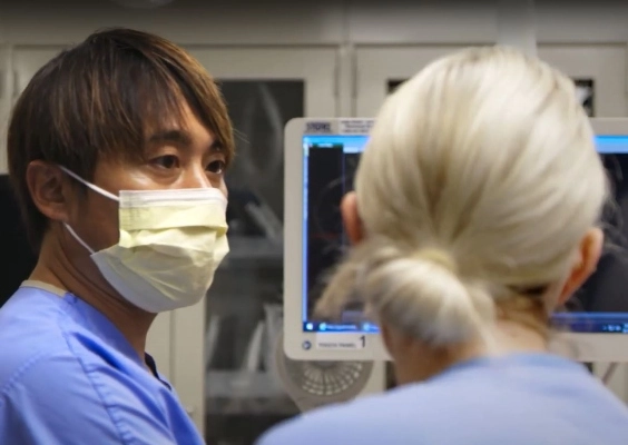 A faculty member and fellow discuss care while performing a procedure.