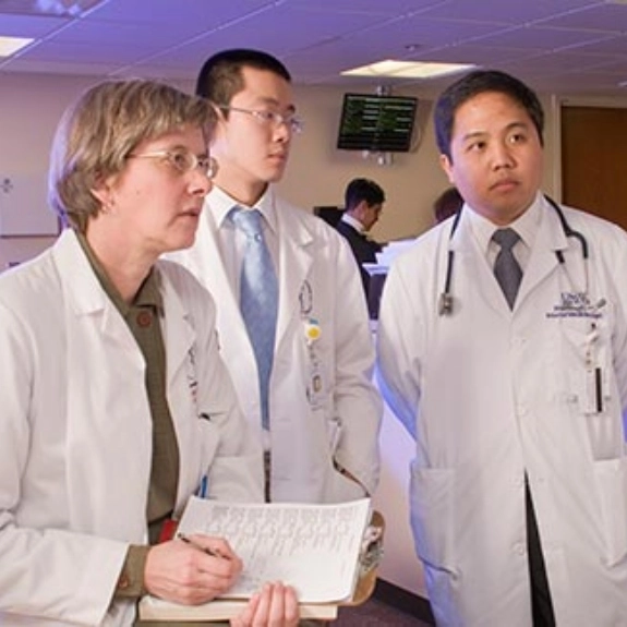 Three fellows observing a medical chart together.