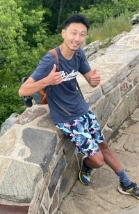 Michael Chen giving a thumbs up during a trail hike.