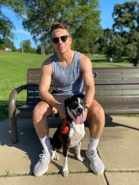 Aidan McGowan sitting on a bench with his dog.