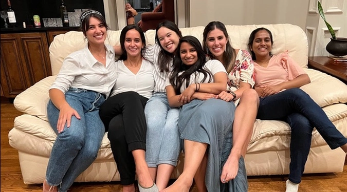 Group of MedPeds residents sitting on a couch together smiling.