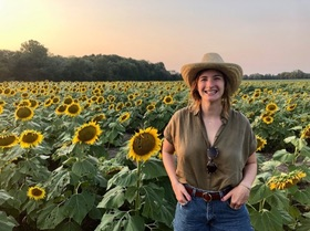 Rachel Oldfather in field of sun flowers.