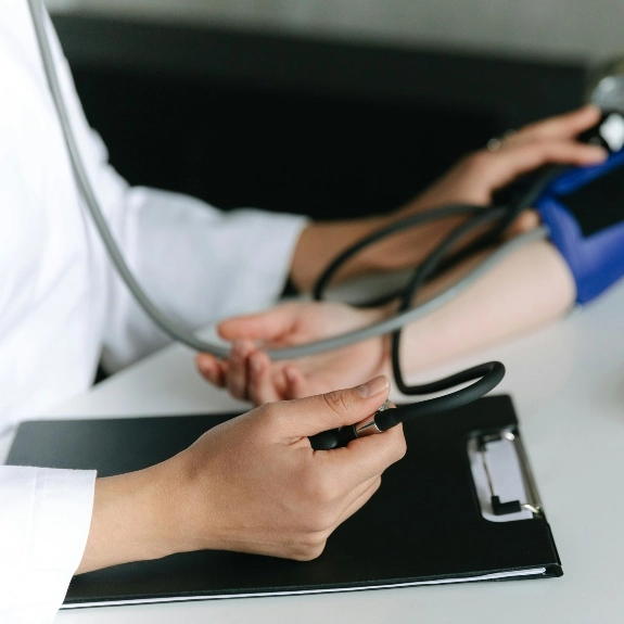 Closeup of a doctor taking the blood pressure of a patient.