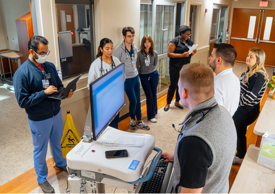 A resident checks patient information at a hospital work station.
