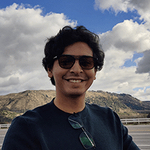 man with blue sky and mountain range behind him