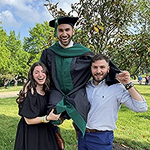 Ameen in commencemnet robe and hat being raised up by two other people