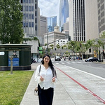 Zainab on a city street with buildings behind her