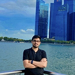 Karnav with a body of water and skyline behind him