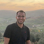 Ehsan with a city in the valley behind him