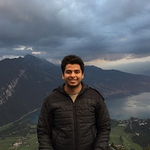 Ramy with mountains and stormy sky behind him