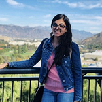 Ujjwal with a scenic background behind her