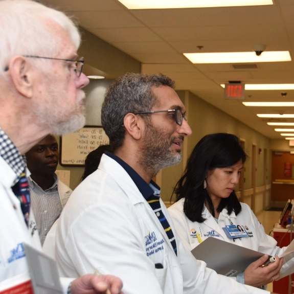 School of Medicine faculty reviewing patient information at a hospital workstation.